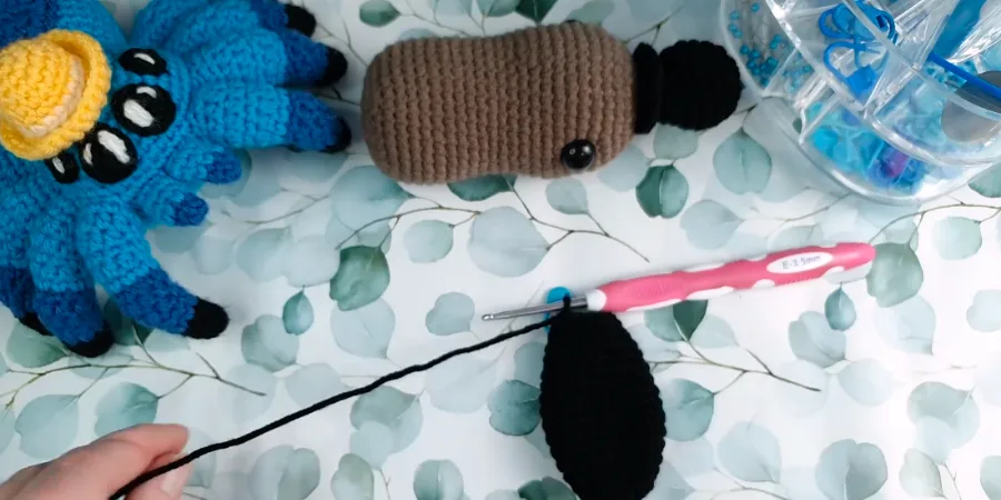 Black crocheted platypus tail piece worked with a crochet hook.