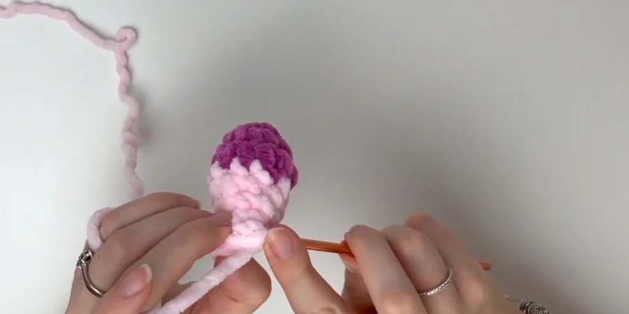 Pink crocheted strawberry cow head and body showing the amigurumi shape