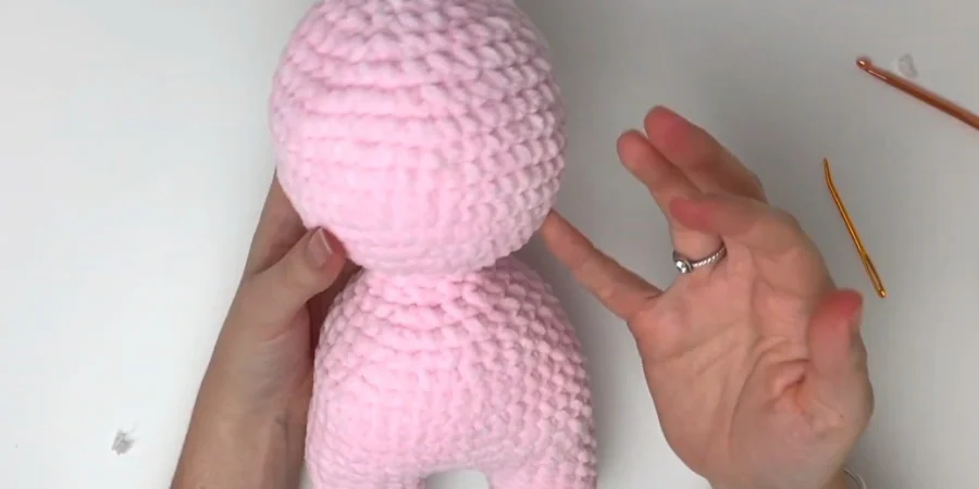 Pink crocheted strawberry cow head and body showing the amigurumi shape