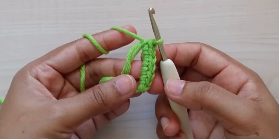 Crochet sunflower center worked in green yarn with 6 single crochet stitches
