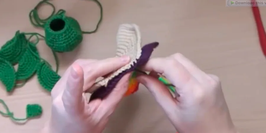 Crochet turtle shell pieces being joined together with yarn and a crochet hook.