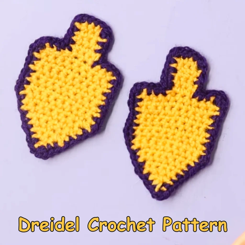 Two finished yellow and purple dreidels with a crochet hook and yarn visible on a light background, labeled “Dreidel Crochet Pattern.”