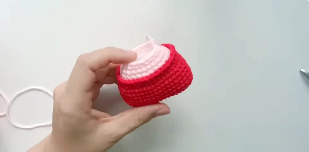Crocheting the red and pink overall-style body of a Hello Kitty amigurumi