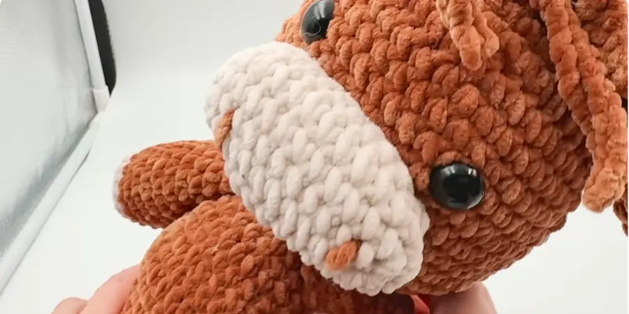 Close-up of the finished Highland cow showing its white muzzle, black eye, and textured brown body.