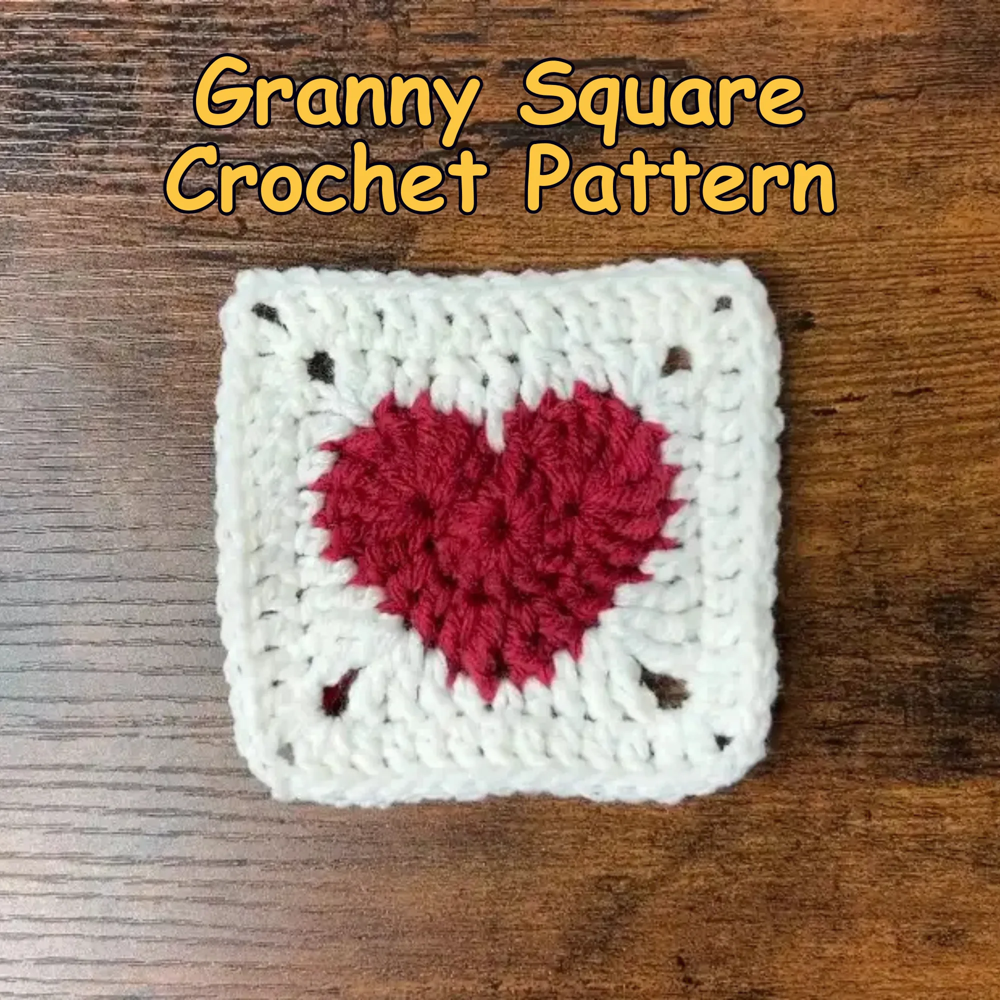 Red heart crochet granny square with a white border on a wooden surface, labeled “Granny Square Crochet Pattern.”