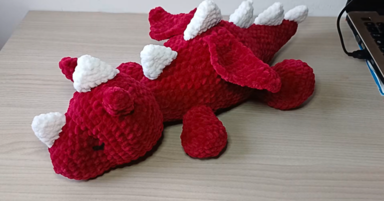 1. Finished red and white crochet dragon amigurumi with wings, horns, back spikes, and legs