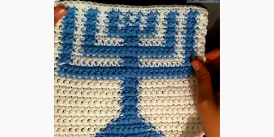 Completed blue and white crocheted Hanukkah Menorah with a central stem, base, candles, and decorative border.