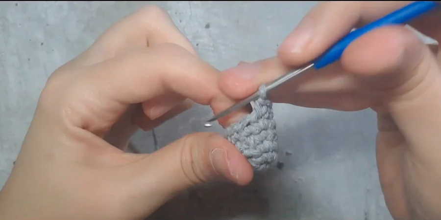 Close-up of a grey crocheted Totoro ear being worked with a crochet hook