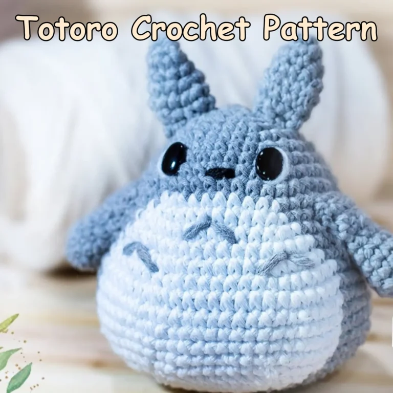 Totoro crochet pattern showing a finished grey and white crocheted Totoro with black safety eyes, pointed ears, arms, and embroidered belly details